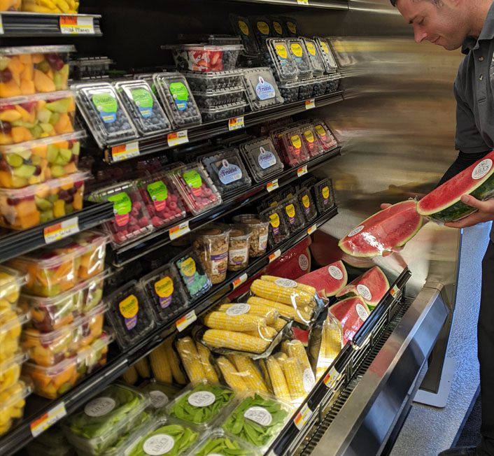 someone holding a box full of produce