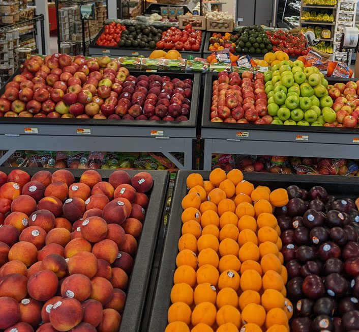 someone holding a box full of produce